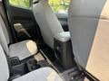 Interior view of the back seat area of a 2017 Chevrolet Colorado showing two grey cloth seats and a center console with cup holders