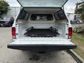 A 2013 RAM 1500 with its rear bed and cover open displaying a black bed tray inside