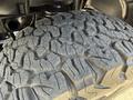 Close-up of a rugged tire tread from a 2021 Jeep Wrangler showcasing deep grooves designed for off-road performance