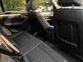 Interior view of a 2013 BMW X3 showing the spacious back seats with black leather upholstery and headrests