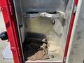 Open compartment of a 2007 GMC C4500 TopKick showing empty space with metal brackets and a brown cloth on the floor