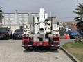 A 2012 International 7300 Workstar truck viewed from the rear with a mounted lift mechanism and various lights on the back panel