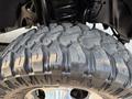 Close-up of a rugged tire with deep treads designed for off-road performance mounted on a 2021 Ford F-350 SD vehicle