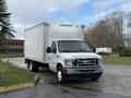 A 2022 Ford E-450 box truck in white parked at an angle with a cargo area and a front grill featuring the Ford logo