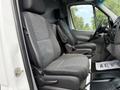 Interior view of a 2012 Mercedes-Benz Sprinter showing two black fabric front seats with armrests and a dashboard visible