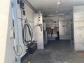 Interior view of a 2008 Wells Industries Inc EW1422 with metal shelves and equipment mounted on the walls and a plumbing setup at the back