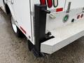 A 2024 RAM 5500 with a white exterior features a diamond plate rear step and a black utility attachment bolted to the back