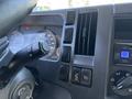 Dashboard controls and instrument panel of a 2016 Isuzu NPR-HD with gauges and buttons for various functions