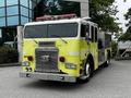 A 1995 Freightliner FLL086 fire truck with a bright yellow exterior features multiple lights and a prominent grille with chrome accents