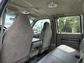 Interior view of a 2008 Ford F-550 showing two front seats and a bench seat with gray upholstery