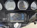 Close-up of a 2017 Harley-Davidson FLHTKL dashboard featuring gauge displays and a media control screen showing options for music and rock phone