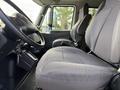 Interior of a 2011 International 4300 showing the driver's seat and passenger seat with grey upholstery and a steering wheel in view