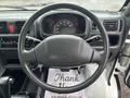 A 2010 Suzuki Carry's steering wheel and dashboard displaying a speedometer and various controls