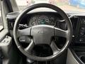 Steering wheel and dashboard of a 2004 Chevrolet Express showing gauges and controls