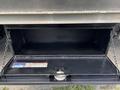 A 2020 Chevrolet Silverado with an open storage compartment featuring a black interior and chains holding the lid up