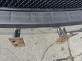 Close-up of the front bumper of a 2018 Chevrolet Express showing two rusty mounting brackets protruding from the bumper