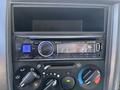 Car stereo system with a CD receiver display and various control knobs for audio settings and Bluetooth connectivity