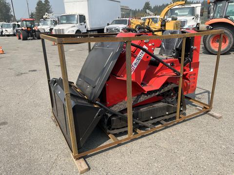 A red 2025 AGT Industrial SDA-140T(Z) compact track loader sits inside a metal frame with an open top showcasing its tracks and attachment points
