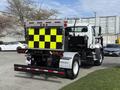A 2016 Freightliner 108SD truck with a rear-mounted safety sign featuring black and yellow checkerboard patterns and reflective lights