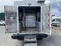 A 2015 Ford F-550 with an open rear cargo area showcasing metal shelving and hooks on the walls