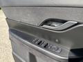Interior door panel of a 2023 Fisker Ocean featuring window controls and a sleek design