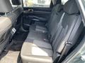 A spacious rear seating area of a 2022 Kia Sorento with black fabric upholstery and seat belts visible