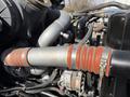 Close-up of a diesel engine showing metallic components including pipes hoses and clamps with a prominent red rubber connector