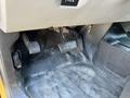 The footwell of a 2013 Chevrolet Silverado 1500 showing the gas pedal brake pedal and clutch pedal with a dark carpeted surface