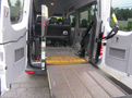 2009 Dodge Sprinter Van with an open rear door showcasing a wheelchair lift and spacious interior with multiple seats visible