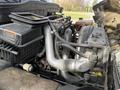 Close-up of the engine compartment of a 2012 International DuraStar 4300 showing various components including pipes and an air filter box