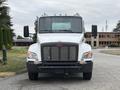 A white 2025 Peterbilt 536 truck with a prominent grille and headlights is facing directly towards the viewer