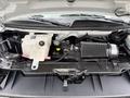 The image shows the engine compartment of a 2004 Chevrolet Express with various components including the coolant reservoir air intake and other engine parts