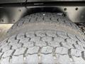 Close-up of a worn tire from a 2013 Freightliner 114SD showing distinct tread patterns and grooves