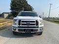 A white 2016 Ford F-150 truck is parked on the street facing the camera with a chrome grille and prominent headlights