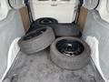 A 2019 Ford Transit Connect with four black tires loaded in the cargo area