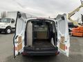 A white 2017 Ford Transit Connect with its rear doors open showing the empty cargo area and interior storage configurations