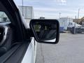 A side mirror of a 2021 Ford F-150 showing the reflection of the truck's interior and nearby vehicles