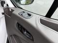 Interior door handle and controls of a 2020 Ford Transit with a textured panel and a window control button
