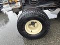 A close-up of the tire and wheel of a 2012 Kubota F3680 showcasing a rugged tread pattern on a black tire with a cream-colored wheel