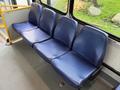 A row of four blue fabric seats with a mesh pattern designed for passenger use in a vehicle