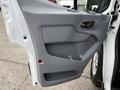 A gray interior door panel from a 2017 Ford Transit T150 XLT featuring a handle, armrest, and speaker area