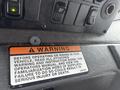 A close-up of the dashboard of a 2006 E-One Typhoon showing warning labels and control buttons