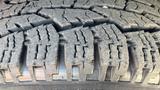 Close-up view of the tread pattern on a tire of a 2016 Ford F-150 showcasing deep grooves and a rugged design for traction and durability on various terrains
