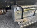 A metal fuel tank mounted on the side of a 2022 Freightliner M2 106 truck with a circular cap and textured step area next to it