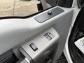 A close-up view of the door panel of a 2012 Ford F-550 featuring window controls and a handle
