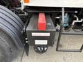 A black battery box with a red cover labeled DO NOT STEP located on the side of a 2010 Autocar Xpeditor truck