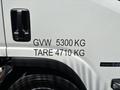 A white 2016 Isuzu NPR-HD with markings displaying GVW 5300 KG and TARE 4710 KG on the side of the vehicle