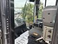 Interior cabin of a 2012 Caterpillar 980 featuring a driver's seat control panel and display screen with various controls and levers