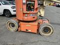 A 2009 JLG E300AJP aerial work platform with a bright orange exterior featuring two large rubber tires and a control panel visible on the side