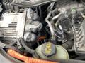 A close-up view of the engine compartment of a 2021 Ford Explorer displaying parts such as the engine block and various hoses and cables